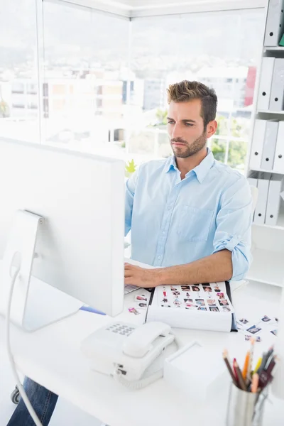 Concentrated male photo editor working on computer — Stock Photo, Image