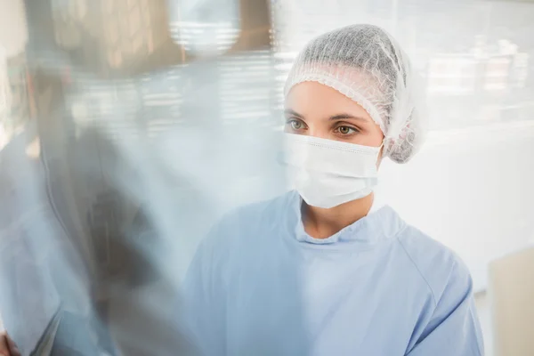 Cirujano femenino serio examinando radiografía borrosa —  Fotos de Stock