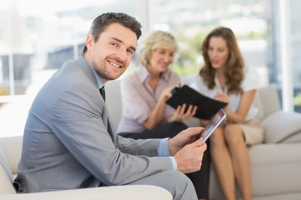 Businessman using digital tablet with colleagues at home — Stock Photo, Image