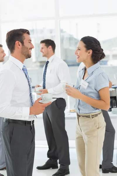 Collega's in discussie met kopjes thee tijdens pauze — Stockfoto