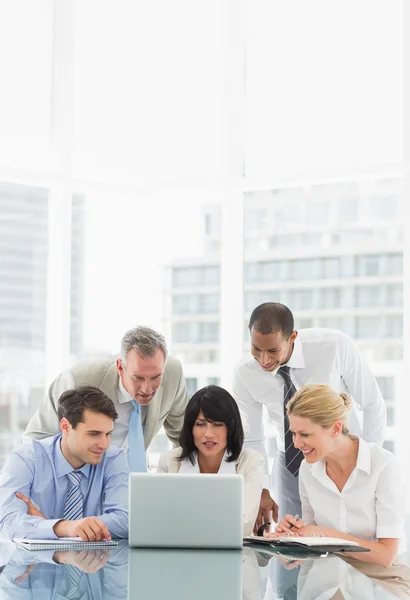 Happy business people gathered around laptop discussing — Stock Photo, Image