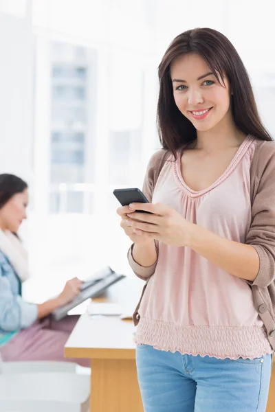 Portrait of a smiling casual young woman text messaging — Stock Photo, Image