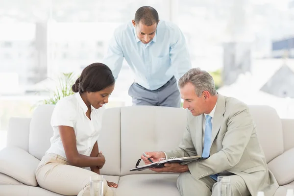 Salesman showing client where to sign the paperwork — Stock Photo, Image