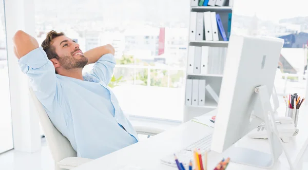 Homme décontracté reposant les mains derrière la tête au bureau — Photo