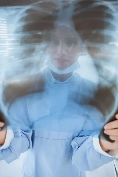 Female surgeon examining blurred x-ray — Stock Photo, Image