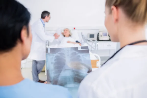 Rear view of doctors with blurred patient in hospital — Stock Photo, Image