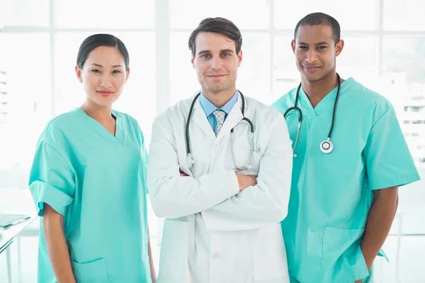 Drie artsen staande samen in ziekenhuis — Stockfoto