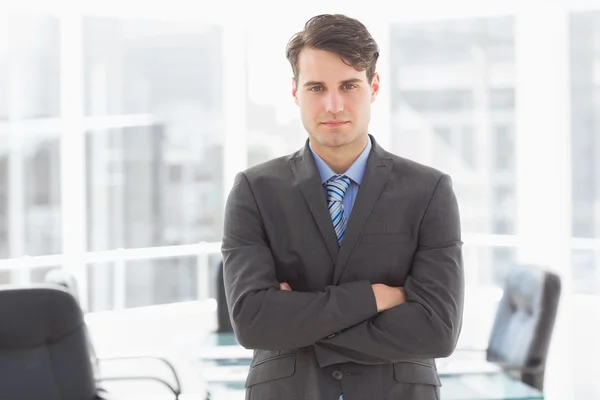 Handsome businessman leaning on board room table — Stock Photo, Image