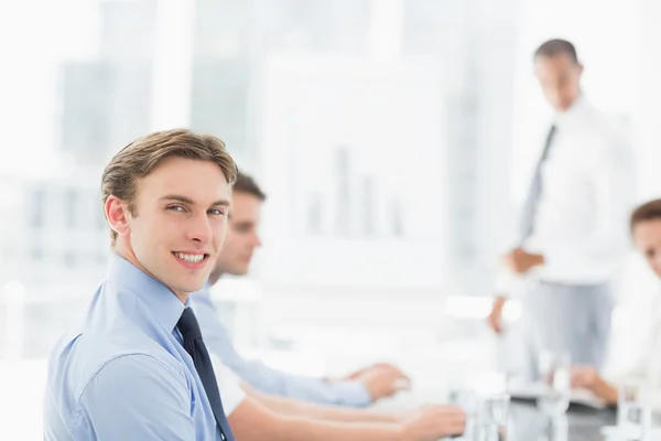 Lächelnder Geschäftsmann blickt während eines Meetings in die Kamera — Stockfoto