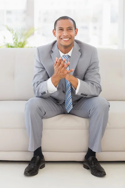 Empresário animado sentado no sofá — Fotografia de Stock
