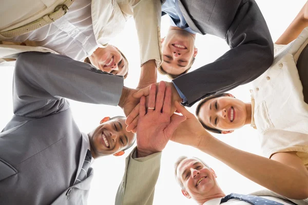 Cheerful business team looking down at the camera with hands tog — Stock Photo, Image