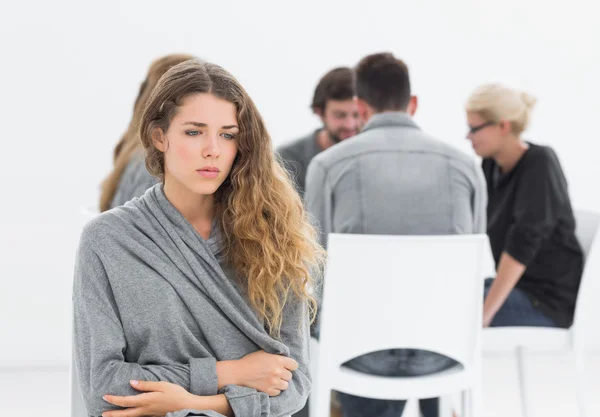 Therapy in session sitting in a circle while woman in foreground — Stock Photo, Image