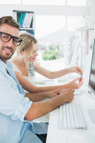 Smiling casual young couple working on computer — Stock Photo, Image