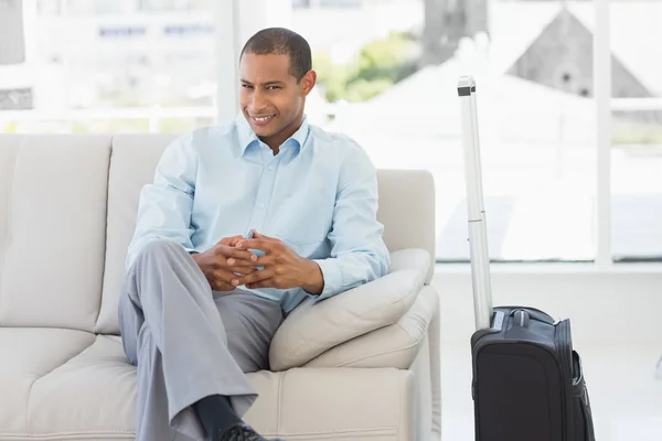 Glad affärsman sitter på soffan väntar på att avvika på business — Stockfoto