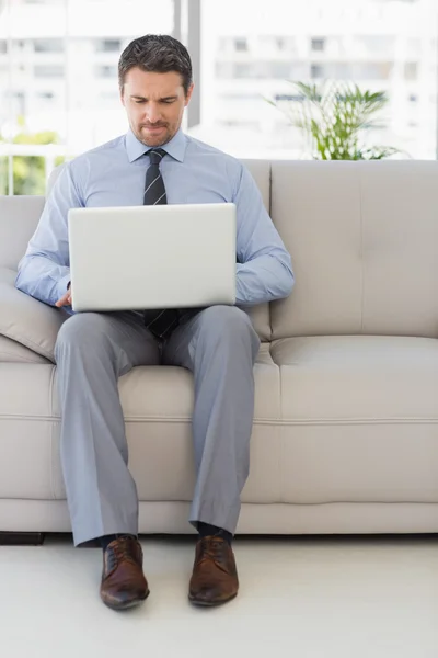 Välklädd man använder laptop hemma — Stockfoto