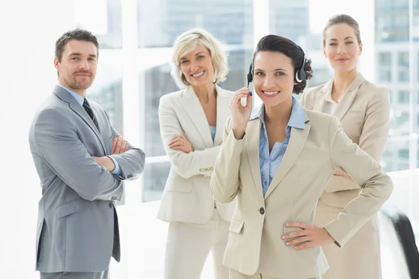 Businesswoman wearing headset with colleagues in office — Stock Photo, Image