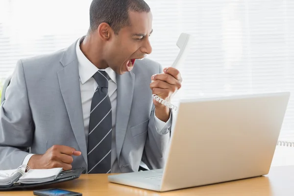Бизнесмен кричит в телефон в офисе — стоковое фото