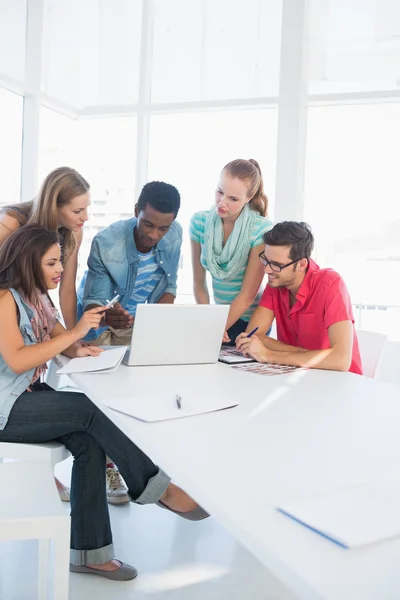 Jóvenes casuales usando portátil en la oficina — Foto de Stock