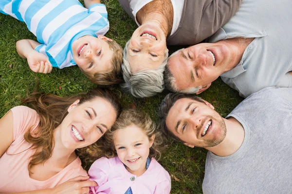 Uitgebreide familie liggen in cirkel in het park — Stockfoto