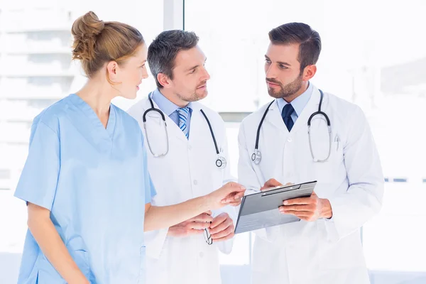 Doctors and female surgeon reading medical reports — Stock Photo, Image