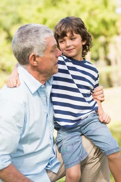Grootvader en zoon glimlachend in het park — Stockfoto