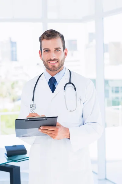 Retrato de un médico varón confiado con portapapeles — Foto de Stock