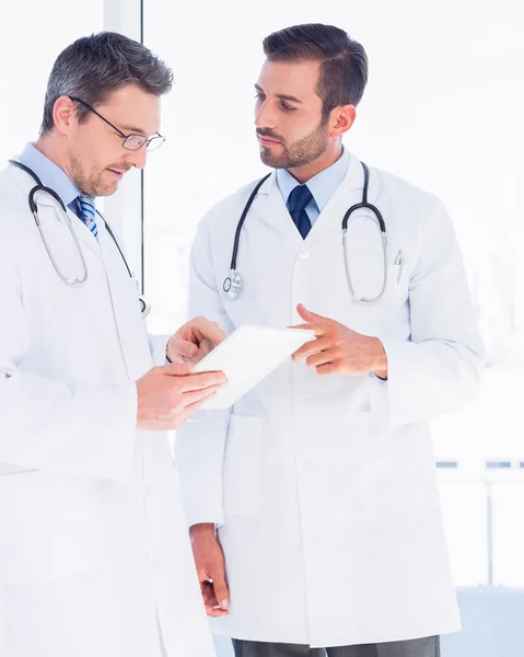 Médicos usando tablet digital em consultório médico — Fotografia de Stock