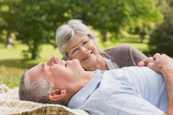 Side of a senior couple lying at park — Stock Photo, Image