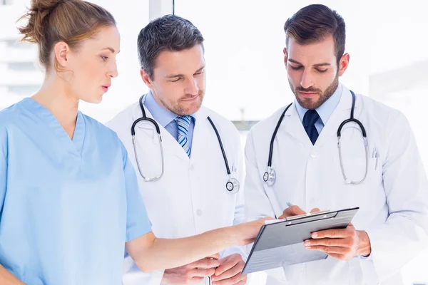 Doctors and surgeon reading medical reports — Stock Photo, Image