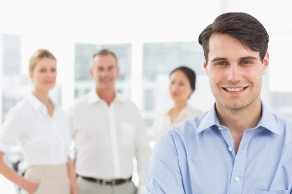 Smiling businessman standing with team behind him — Stock Photo, Image