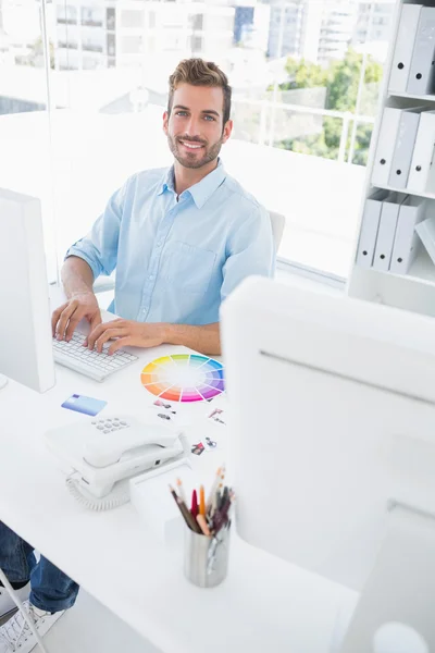 Éditeur de photo masculin souriant à l'aide d'un ordinateur — Photo