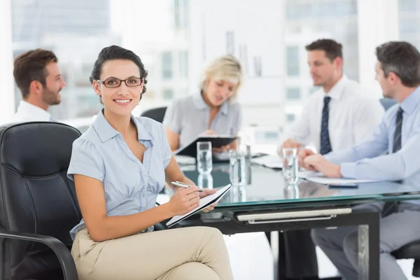 Empresária segurando prancheta com colegas discutindo em de — Fotografia de Stock