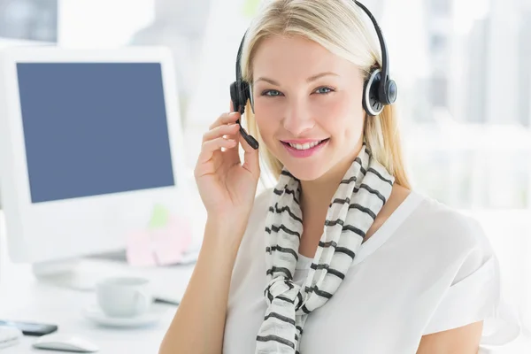 Smiling casual young woman with headset in office — Stock Photo, Image