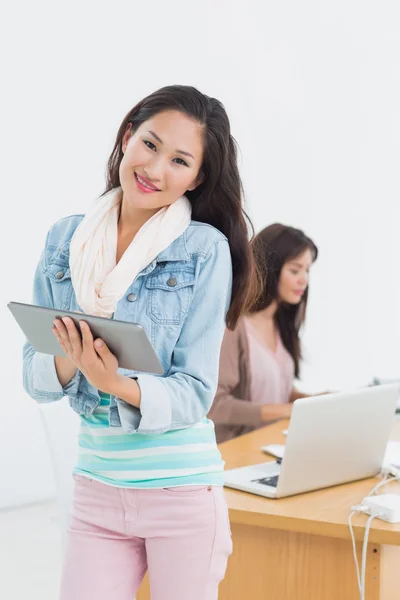 Casual konstnär med digital tablet med kollega i bakgrunden — Stockfoto