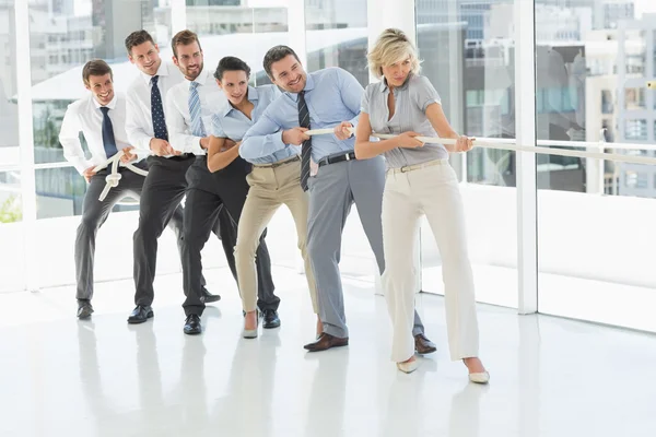 Group of business people pulling rope in office — Stock Photo, Image