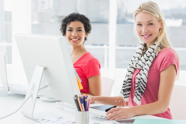 Collèges féminins utilisant un ordinateur dans un bureau lumineux — Photo