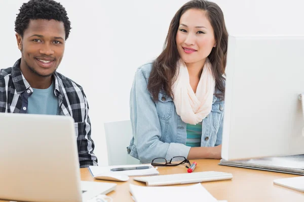 Couple occasionnel utilisant des ordinateurs dans le bureau — Photo