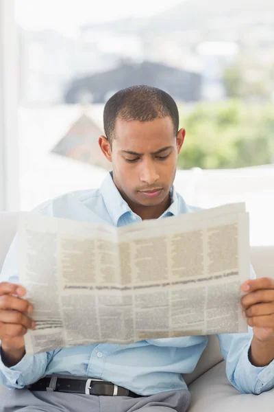 Homme d'affaires sérieux lisant un journal sur le canapé — Photo