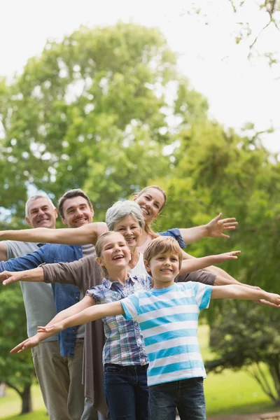 Utvidgade familjen sträcker händerna på park — Stockfoto
