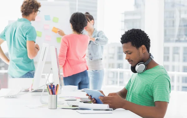 Uomo casual che utilizza tablet digitale con colleghi in carica — Foto Stock