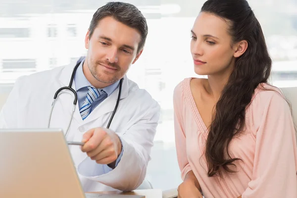 Mužské doktor něco ukazuje na notebooku pacienta — Stock fotografie