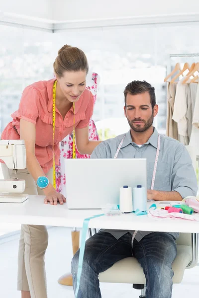 Fashion designers using laptop in bright studio — Stock Photo, Image