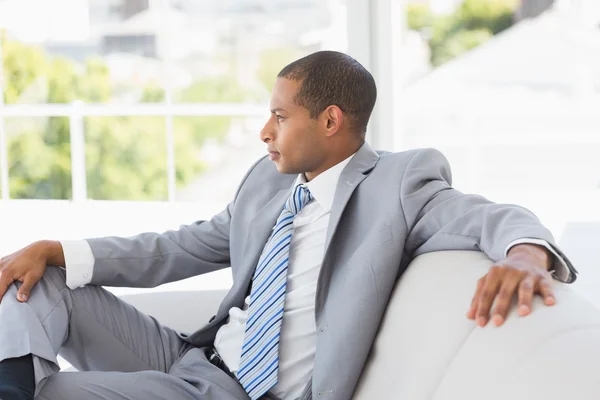 Serious businessman thinking on couch — Stock Photo, Image