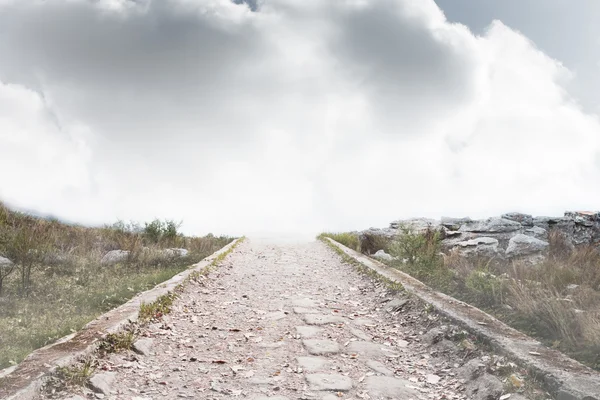 Steiniger Weg führt zum nebligen Horizont — Stockfoto