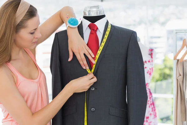 Female fashion designer measuring suit on dummy — Stock Photo, Image