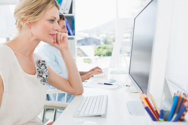 Lächelndes junges Paar, das an Computern arbeitet — Stockfoto