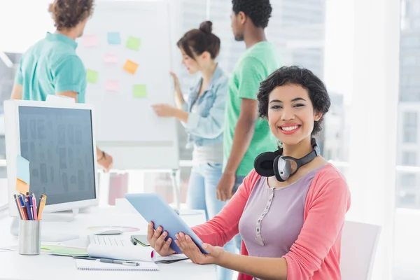 Casual woman with group of colleagues behind in office — Stock Photo, Image