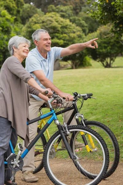 Pareja mayor en paseo en bicicleta en el campo — Foto de Stock