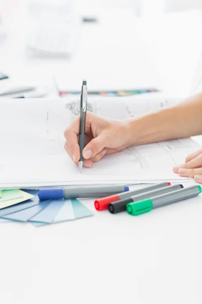 Artista dibujando algo en papel con pluma en la oficina —  Fotos de Stock