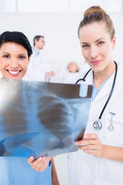 Portrait of a smiling doctor and surgeon examining x-ray — Stock Photo, Image